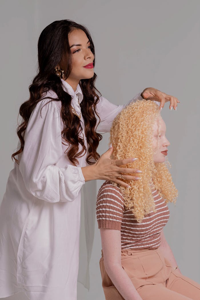 services-03 Hair stylist working on diverse women's hairstyles in a studio setting.